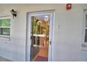 Inviting front door with glass insert allowing natural light, complemented by a wall-mounted lantern fixture at 200 El Camino Dr # 206, Winter Haven, FL 33884