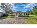 Charming guest house with an inviting exterior, beautiful landscaping, and a paved driveway at 2300 N Scenic Hwy # 89, Lake Wales, FL 33898