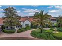 Elegant home with a red tile roof, paver driveway and lush landscaping including a three-tiered fountain at 2300 N Scenic Hwy # 61, Lake Wales, FL 33898