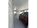 Well-lit carport with ample space for parking and relaxing outdoor furniture at 32 Berna Cir, Winter Haven, FL 33884