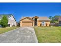 Charming single-story home featuring a two-car garage, arched entryway, and well-maintained front yard at 3430 Cove E Ct, Winter Haven, FL 33880