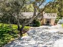 Exterior view of the home showcasing the driveway, landscaping, and charming architectural details at 3614 Twisted Oak Ct, Lake Wales, FL 33898