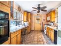 Functional kitchen featuring wooden cabinets, tile flooring, and a window overlooking the backyard at 3655 N Scenic Hwy, Lake Wales, FL 33898