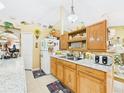 Bright kitchen featuring oak cabinetry, granite countertops, and plentiful counter space at 3690 Wellington Pl, Bartow, FL 33830