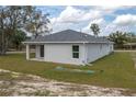 View of the back of the house showing the covered porch, windows, and well-maintained lawn at 42 Mountain Dr, Babson Park, FL 33827