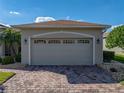 Spacious two-car garage with traditional doors and brick-paved driveway for easy access at 4232 Roebelenii Dr, Lake Wales, FL 33859
