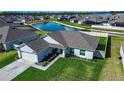 Aerial view of home with a well-manicured lawn, water view, and easy neighborhood access at 447 Lanham Dr, Winter Haven, FL 33881