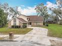 Attractive home with a long driveway, brick accents, siding, and a tidy front yard at 4765 Lantern Ct, Orlando, FL 32808