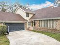 View of home, garage and driveway. The house is sided with brick on the lower level at 4765 Lantern Ct, Orlando, FL 32808