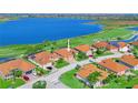 Aerial view of a residential area featuring homes with well-manicured lawns and a beautiful lake at 5268 Pebble Beach Blvd, Winter Haven, FL 33884