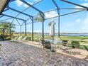 Relaxing screened patio with outdoor furniture, offering stunning views of the golf course and lake at 5268 Pebble Beach Blvd, Winter Haven, FL 33884