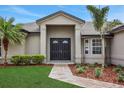 Home's front entrance features a double door and walkway surrounded by landscaping at 583 Drayton Rd, Winter Haven, FL 33884