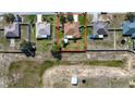 Aerial view of a property with a well-maintained lawn surrounded by neighboring houses and greenery at 625 Hatchwood Dr, Haines City, FL 33844