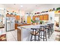 Bright kitchen features white tile flooring, a breakfast bar, and wooden cabinets at 625 Hatchwood Dr, Haines City, FL 33844