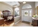 Elegant foyer with tile flooring, arched transom window and a view into the formal dining room at 7327 Bent Grass Dr, Winter Haven, FL 33884