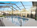 Screened-in pool area with water feature, surrounded by patio and lush landscaping, perfect for relaxation at 7327 Bent Grass Dr, Winter Haven, FL 33884