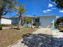 Charming single-story home with a well-manicured front yard, garage, palm trees, and inviting entryway at 915 Exmoor Way, Lake Wales, FL 33853