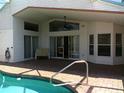 Covered outdoor patio with brick flooring, ceiling fan, sliding glass doors, and direct access to the pool at 100 Heatherwood Blvd, Lake Wales, FL 33859