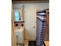 Cozy bathroom with tiled flooring, a shower with blue-striped curtain, and a vanity at 1405 N Lake Reedy Blvd, Frostproof, FL 33843