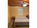 Simple bedroom with a neutral color palette, shuttered windows, and a ceiling fan at 1405 N Lake Reedy Blvd, Frostproof, FL 33843