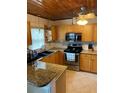 Traditional kitchen featuring oak cabinets, granite countertops, and stainless steel appliances at 1405 N Lake Reedy Blvd, Frostproof, FL 33843