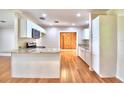 Bright kitchen featuring granite countertops, stainless steel appliances, and hardwood floors at 1475 S Lake Howard Dr, Winter Haven, FL 33880