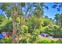 Private backyard with mature trees, lush landscaping, and peaceful fountain at 200 El Camino Dr # 202, Winter Haven, FL 33884