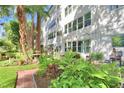 Apartment building exterior featuring a patio with lush, colorful gardens at 200 El Camino Dr # 202, Winter Haven, FL 33884