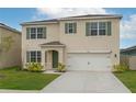Charming two-story home featuring a well-manicured lawn, neutral stucco, attached garage and colorful green shutters at 2005 Carnostie Rd, Winter Haven, FL 33884