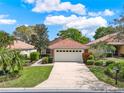Landscaped single-story home with a tile roof, featuring a lush lawn and a spacious two-car garage at 208 Lake Region S Blvd, Winter Haven, FL 33881