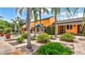 Beautiful home exterior featuring an expansive garden with lush greenery, palm trees, and ample outdoor seating at 2300 N Scenic Hwy # 56, Lake Wales, FL 33898