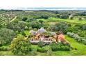Beautiful aerial view of a house surrounded by lush greenery, an orchard and a stunning pool at 2300 N Scenic Hwy # 56, Lake Wales, FL 33898