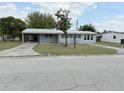 Single-story home with a metal roof, lush lawn and an extended carport at 253 Walter Ave, Frostproof, FL 33843