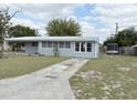 Cozy single-story home with a metal roof, large driveway, and lush green lawn at 253 Walter Ave, Frostproof, FL 33843