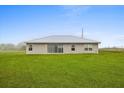 Home back exterior featuring large windows and sliding glass door at 3608 Garrard Rd, Fort Meade, FL 33841