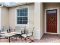 Close-up of a welcoming front porch with seating area and a charming red front door at 4009 Bedford Ave, Winter Haven, FL 33884