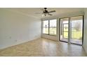 Cozy living room with tiled floor, ceiling fan, and screened porch entrance with natural light at 404 Laurel Cove Way # 404, Winter Haven, FL 33884