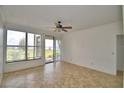 Bright and spacious living room with tiled floors, ceiling fan, and sliding glass doors offering scenic views at 404 Laurel Cove Way # 404, Winter Haven, FL 33884