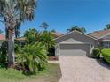 Inviting single-story home with lush landscaping, a brick driveway, and a two-car garage at 4168 Aberdeen Ln, Lake Wales, FL 33859