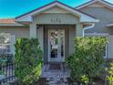 Attractive front entrance with glass doors, brick walkway, and well-maintained landscaping at 4485 Turnberry Ln, Lake Wales, FL 33859