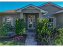 Welcoming front entry with a brick walkway, manicured bushes, and a charming wreath at 4485 Turnberry Ln, Lake Wales, FL 33859