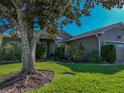 Lush green lawn with mature tree providing shade to this single-story home at 4485 Turnberry Ln, Lake Wales, FL 33859