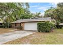 This brick home features an attached garage and lush landscaping, showcasing its curb appeal at 4615 Reynosa Sw Dr, Winter Haven, FL 33880