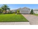 Charming single Gathering home features lush landscaping, brick driveway, and a two-car garage at 462 Lake View Way, Auburndale, FL 33823