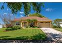 Inviting single-story home with a lush green lawn, mature trees, and a charming front entrance at 633 Hart Lake Dr, Winter Haven, FL 33884