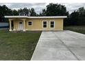 Charming single-story home with a sunny yellow exterior and a spacious concrete driveway at 708 E Broadway St, Fort Meade, FL 33841