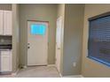 Inviting foyer with stylish tile flooring, a windowed front door, and adjacent kitchen area at 708 E Broadway St, Fort Meade, FL 33841