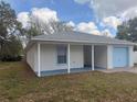Side view of a single-story home highlighting the covered porch and one-car garage at 847 Kristen Ct, Bartow, FL 33830