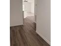 Interior view of a hallway with new wood-look flooring leading to a bright, open living space at 847 Kristen Ct, Bartow, FL 33830