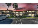 Two-story building with a parking lot in front and palm trees, under a red sky at dusk at 900 Avenue Z Se # A3, Winter Haven, FL 33880